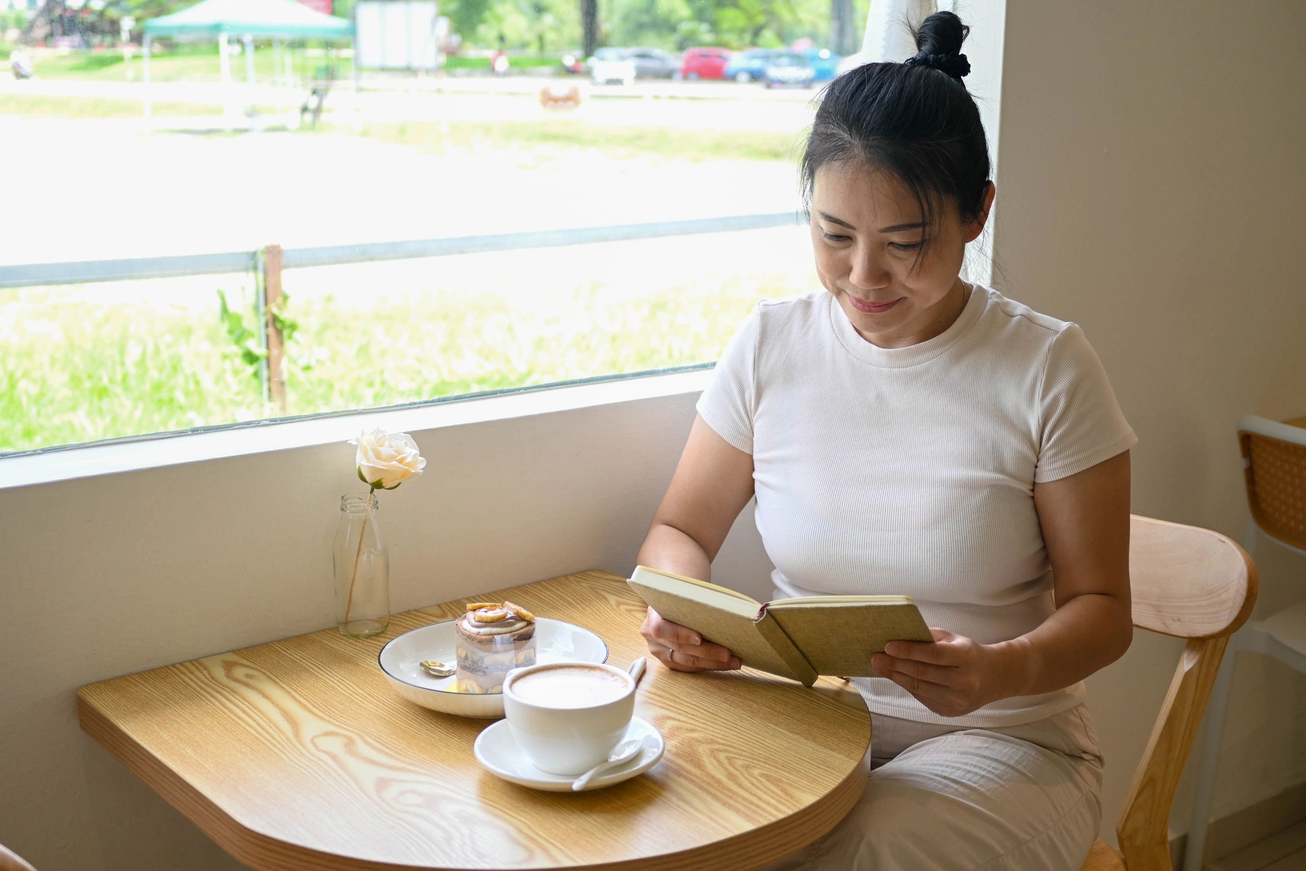 Smiling woman enjoying a peaceful moment with coffee and notes
